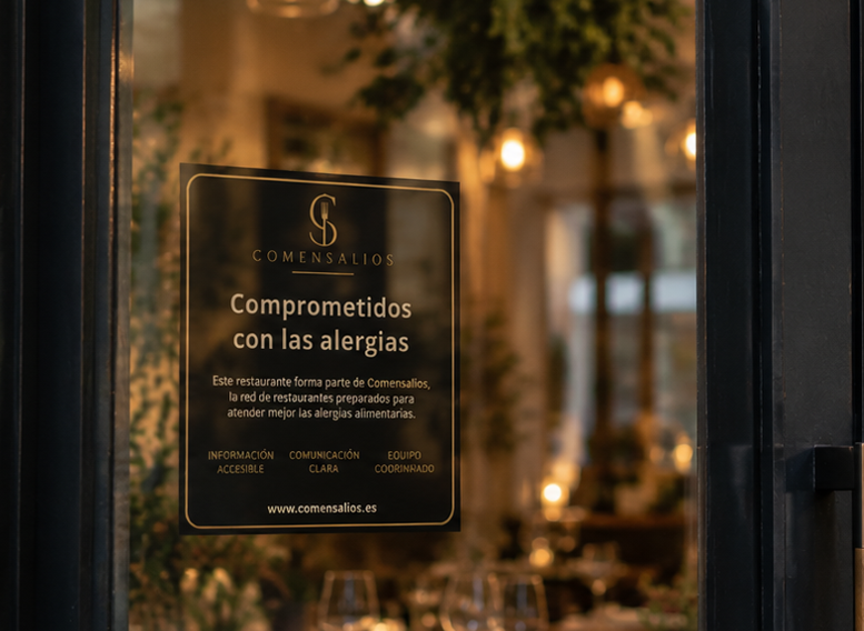 Vinilo Comensalios «Comprometidos con las alergias» en la puerta de un restaurante
